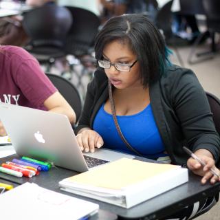 Student is typing on a laptop