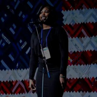 student in front of flag