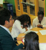 Students write together at a table