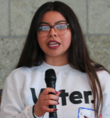 Student holds a microphone while speaking