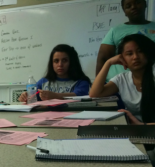 Students around a desk with papers