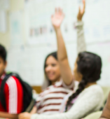 Two students holding their hands up