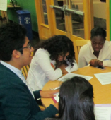 Students write together at a table