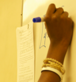 Student's hand writing on a white board