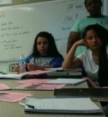 Students around a desk with papers