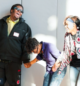 Students holding hands in a line laughing