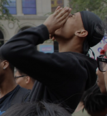 A student shouts through his hands